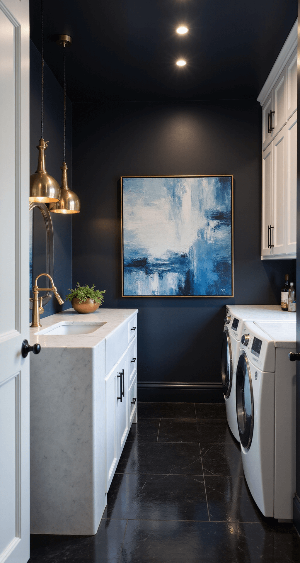 A sophisticated laundry room featuring moody black walls and ceiling with blue undertones, sleek white appliances and cabinetry, a brilliant white quartz island, and modern gold globe pendant lights, accented with copper and brass details, and a vibrant abstract painting, all illuminated by strategic accent lighting.