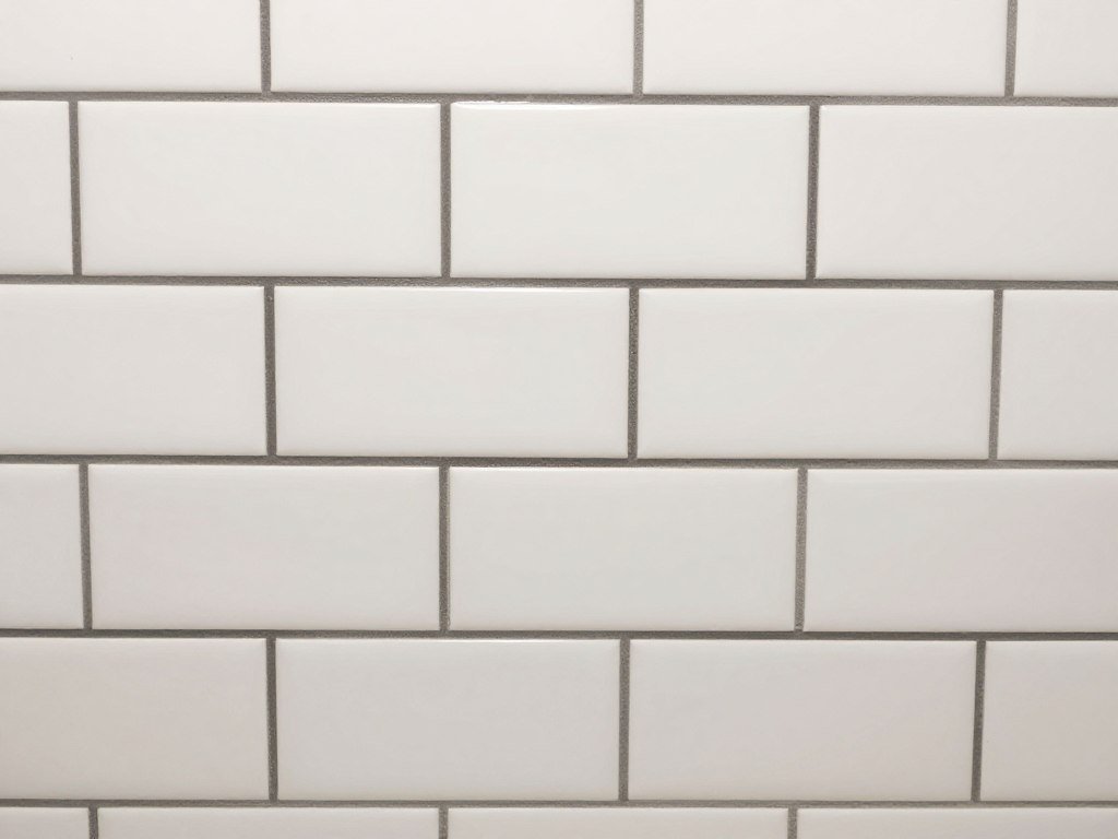 White subway tile with dark contrasting grout creating visual interest in a budget bathroom White subway tile with dark contrasting grout creating visual interest in a budget bathroom
